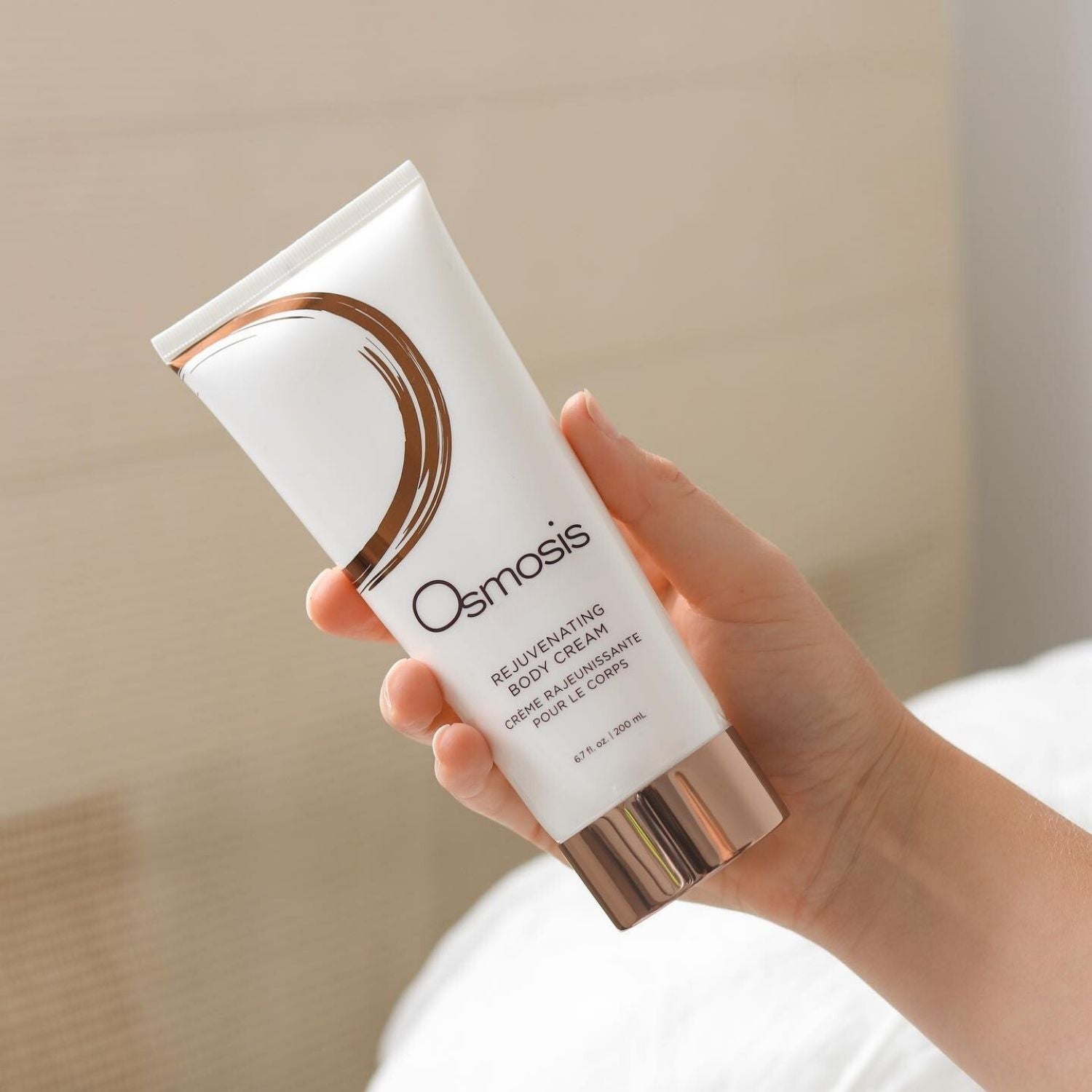 model holding large bottle of body cream by osmosis