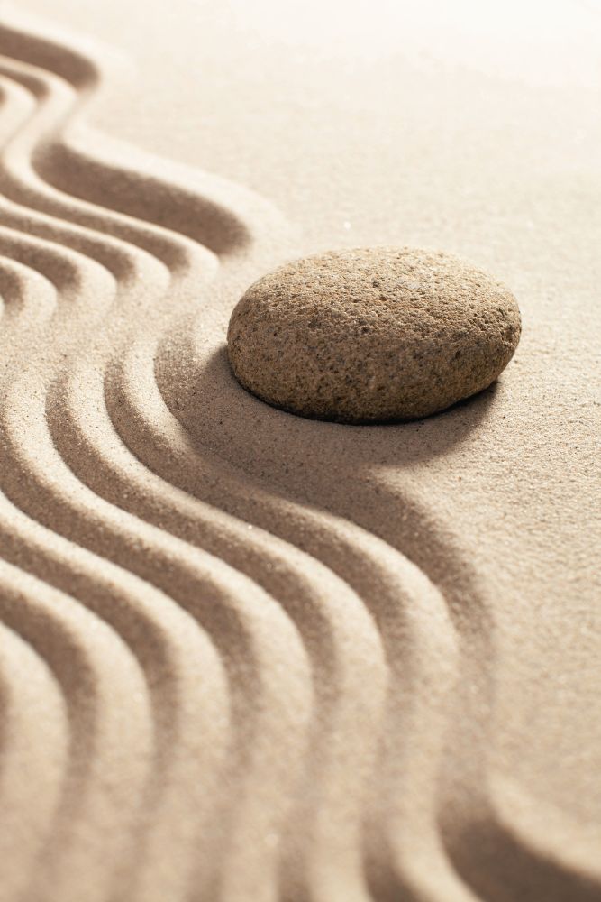 Stone in the sand with raked lines