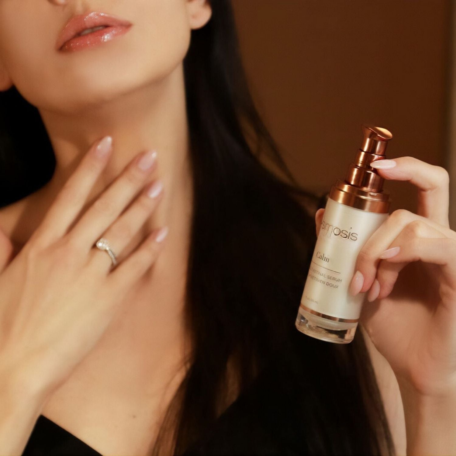 Model holding a bottle of Calm serum by osmosis
