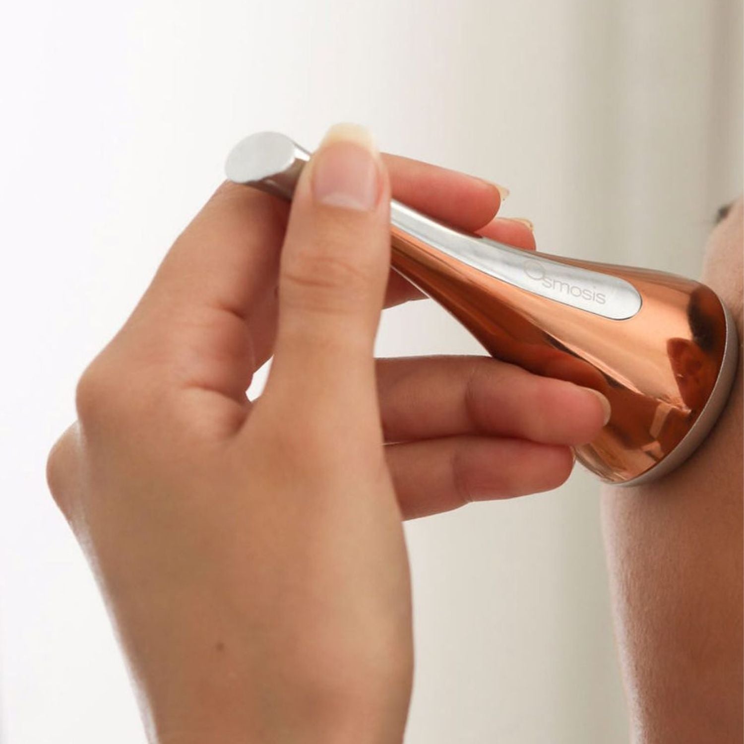 model applying cool skin tool on shoulder