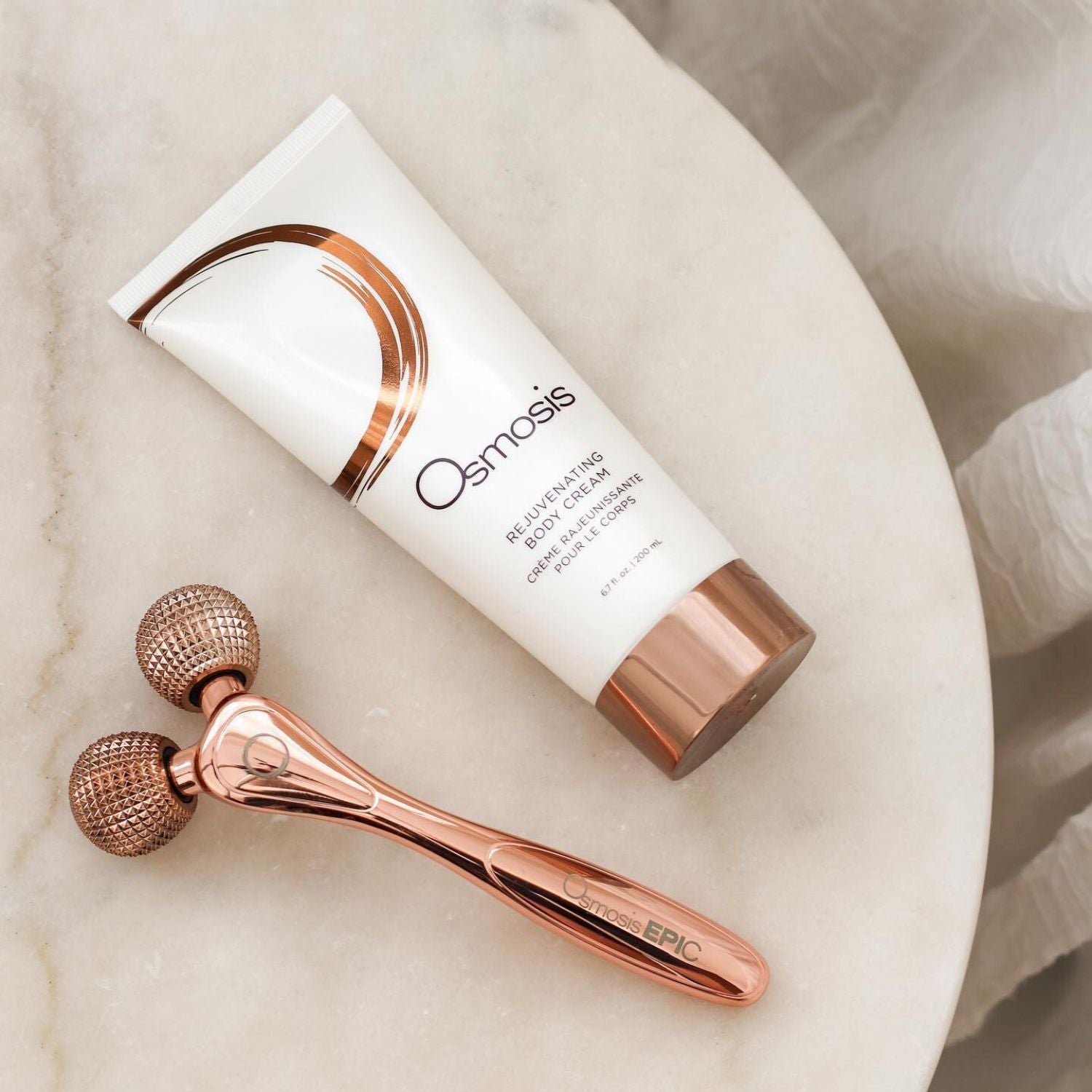 epic body tool displayed next to a bottle of skincare on white table