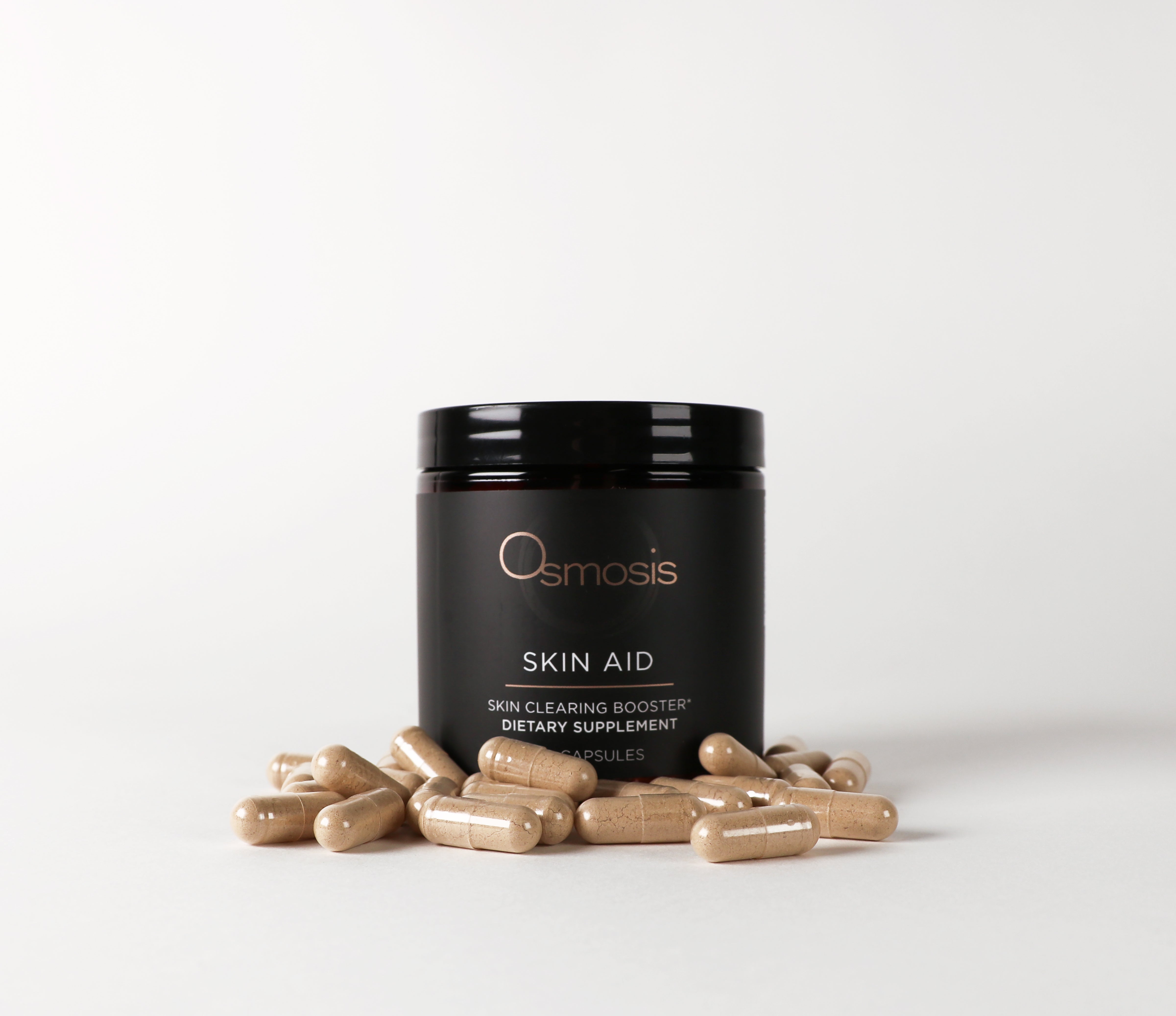 Osmosis Skin Aid black bottle with pills laid in front